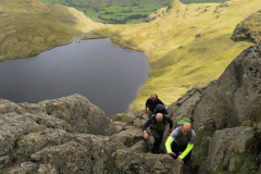 Walkers on Jacks Rake climb, Stickle Tarn beneath