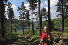 Walker on Win Hill overlooking Ladybower reservoir